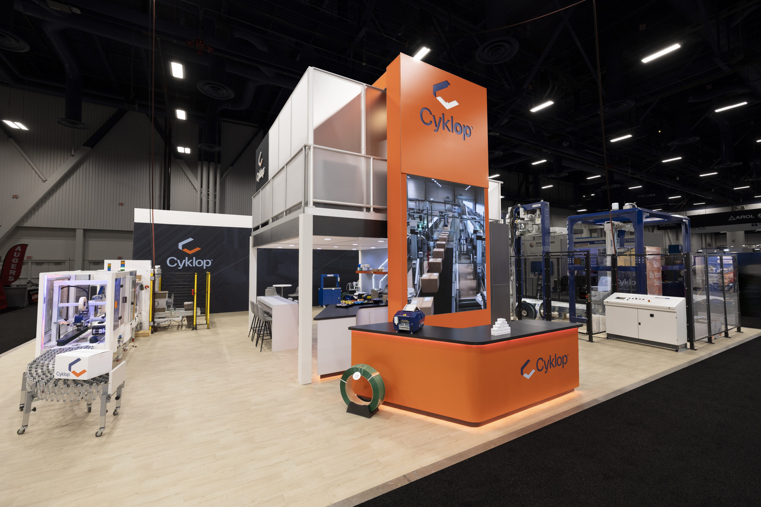 Two-story Cyklop custom trade show exhibit featuring packaging equipment and live demonstration areas